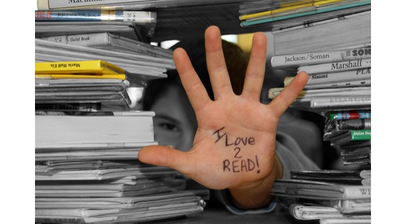 Hand with 'I love to read' surrounded by books