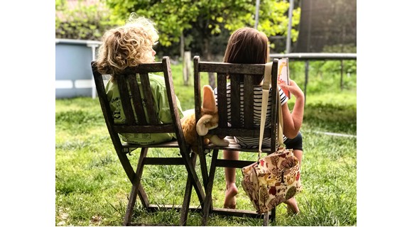 Two little children on chairs outside